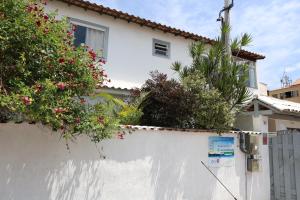 a white wall with plants on top of it at Suítes Praia dos Anjos - Arraial do Cabo in Arraial do Cabo