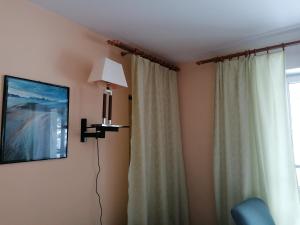 a room with a lamp and a window with curtains at Dom "Honorat", Kamianna 70, 33-336 in Kamianna