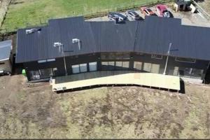a large building with cars parked in a parking lot at Casa nueva en country pucon con piscina y quincho compartido con casa gemela in Pucón