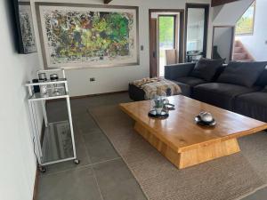 a living room with a couch and a coffee table at Casa nueva en country pucon con piscina y quincho compartido con casa gemela in Pucón