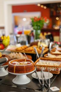 a buffet with cakes and pastries on a table at Carballo Hotel & Spa in Campos do Jordão