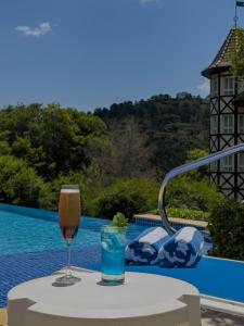 una mesa con una copa de vino y una bebida en Carballo Hotel & Spa en Campos do Jordão