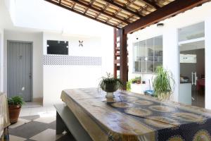 - une salle à manger avec une table et une plante en pot dans l'établissement Suítes Praia dos Anjos - Arraial do Cabo, à Arraial do Cabo