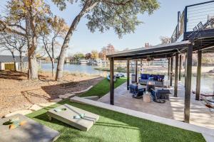 un patio extérieur avec une table et des chaises à côté d'une rivière dans l'établissement Pet-Friendly Lake LBJ Retreat with Deck and Hot Tub!, à Granite Shoals