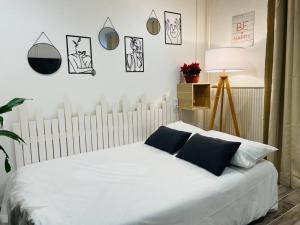 um quarto com uma cama branca e almofadas pretas em Moment magique aux pieds des pistes à Superdevoluy em Le Dévoluy