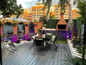 una terraza de madera con mesa y sillas. en Simply relax en Londres