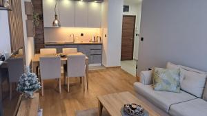 un soggiorno e una cucina con tavolo e divano di Apartman K&N - Jahorinska Vila a Jahorina