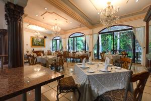 uma sala de jantar com mesas, cadeiras e janelas em Gran Hotel Firenze em Tequisquiapan