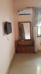 La salle de bains est pourvue d'un miroir et d'une télévision murale. dans l'établissement Dave's abode, à Benin City