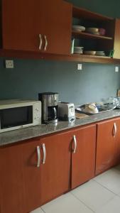 eine Küche mit einer Mikrowelle und einer Arbeitsplatte in der Unterkunft Dave's abode in Benin City