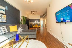 a living room with a couch and a flat screen tv at McCormick 420 friendly 3BR-2BA family unit that sleeps 8 guests with Optional Parking and Gym access in Chicago