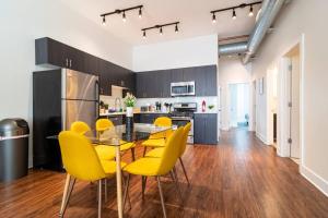 a kitchen with a dining table and yellow chairs at McCormick 420 friendly 3BR-2BA family unit that sleeps 8 guests with Optional Parking and Gym access in Chicago