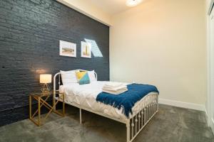a bedroom with a bed and a black brick wall at McCormick 420 friendly 3BR-2BA family unit that sleeps 8 guests with Optional Parking and Gym access in Chicago