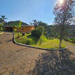 a curve in the road in front of a house at Casa de campo em sítio de médio padrão com piscina aquecida e churrasqueira in Juquitiba