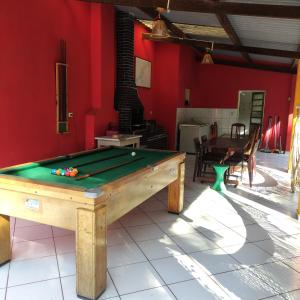 a pool table in a room with red walls at Casa de campo em sítio de médio padrão com piscina aquecida e churrasqueira in Juquitiba