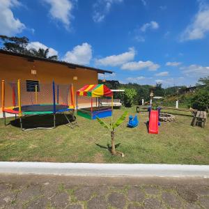 a group of playground equipment in a yard at Casa de campo em sítio de médio padrão com piscina aquecida e churrasqueira in Juquitiba