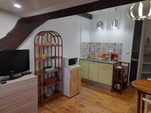 eine Küche mit einem TV und eine Küche mit einer Theke in der Unterkunft L'Anéda - STUDIO vue panoramique sur Mer - 2 personnes - Animaux OK - Wifi in Mers-les-Bains