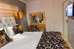 a hotel room with a bed and a desk at Homes of Ace Gold in Pretoria