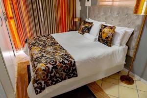 a bedroom with a large bed with white sheets and pillows at Homes of Ace Gold in Pretoria