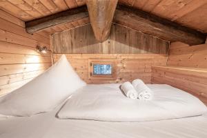 a bed in a wooden room with two towels at Kitzkopf Hütte in Mayrhofen
