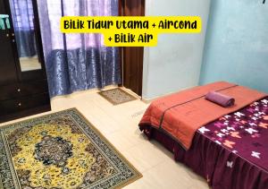 a bedroom with a bed and a rug on the floor at Homestay Kota, Kuala Terengganu FREE WIFI in Kuala Terengganu