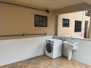 uma casa de banho com uma máquina de lavar roupa e um lavatório em BEAUTIFUL VIEW em Angra dos Reis