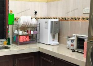 uma cozinha com comodidades para preparar café e um micro-ondas em Homestay Kota, Kuala Terengganu FREE WIFI em Kuala Terengganu
