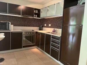 a kitchen with brown cabinets and a stainless steel refrigerator at Alquiler Puerto Madero in Buenos Aires