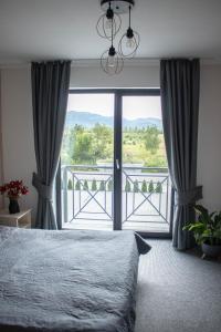 um quarto com uma cama e vista para uma varanda em Готельно-ресторанний комплекс Фамілія em Bushtyno