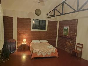 タラポトにあるALMÁZYGO Bed & Breakfastのレンガの壁にベッド1台が備わるベッドルーム1室