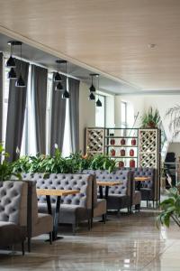 uma sala de jantar com mesas, cadeiras e plantas em Готельно-ресторанний комплекс Фамілія em Bushtyno