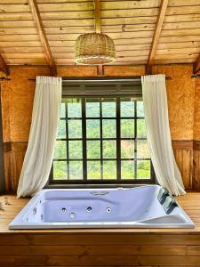 bañera en una habitación con ventana en Pousada Villa da Uva, en Gramado