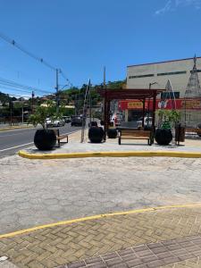 a bus stop with benches on the side of a street at Recanto dos Ganchos in Governador Celso Ramos