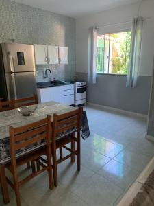a kitchen with a table and chairs and a refrigerator at Recanto dos Ganchos in Governador Celso Ramos