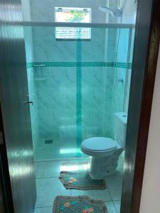 a bathroom with a shower with a toilet and a window at Recanto dos Ganchos in Governador Celso Ramos