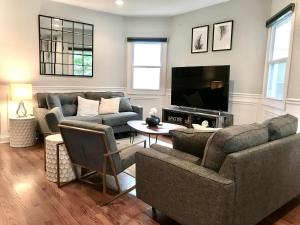 a living room with two couches and a tv at Spacious Home in Downtown Forest Park in Forest Park