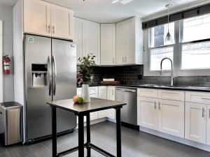 a white kitchen with a table and a refrigerator at Spacious Home in Downtown Forest Park in Forest Park
