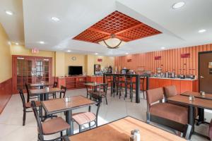 a restaurant with tables and chairs and a bar at Best Western Plus Flowood Inn & Suites in Flowood