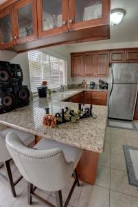 a kitchen with a granite counter top and a refrigerator at 2 story Casual Cute Condo 6 miles from Disneyland & 8 miles Knotts 2bd 2bth Sleeps 8 plus in Cypress