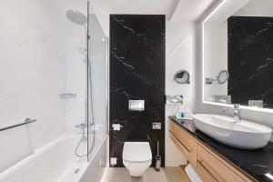 a bathroom with a sink and a toilet and a shower at Radisson Blu Szczecin in Szczecin