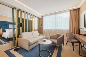 a living room with a couch and chairs and a bed at Radisson Blu Szczecin in Szczecin