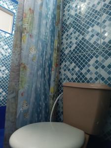 a bathroom with a toilet and a shower curtain at Kitnet no Farol Velho in Salinópolis