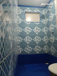 Kitnet no Farol Velho في سالينوبوليس: حمام به جدران من البلاط الأزرق والأبيض ومرحاض