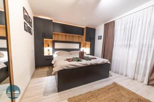 a bedroom with a large bed and a large window at Apartments Ivangrad in Berane