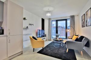 een woonkamer met een bank, stoelen en een tafel bij KA Propertiess - 2Bed & 2Baths Ensuite, Parking, Balcony, Wi-Fi, Netflix, Media City in Manchester