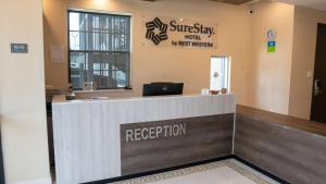 a reception desk in a hospital lobby with a laptop at SureStay Hotel by Best Western Houston Southeast in Houston