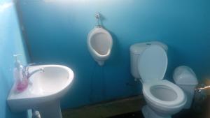 ein Badezimmer mit WC, Urinal und Waschbecken in der Unterkunft Urosfood & Titiqaqa Lodge in Uros