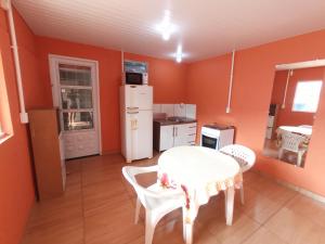 a kitchen with a table and chairs in a room at Casa inteira, Quarto p 3 pessoas com Ar, Sala Cozinha,Wifi,Garagem Coberta in Foz do Iguaçu