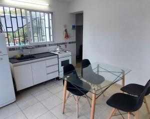 a kitchen with a glass table and four chairs at Don Edelmi in Villa Carlos Paz
