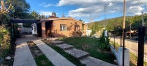 a backyard with a brick house and a fence at Don Edelmi in Villa Carlos Paz
